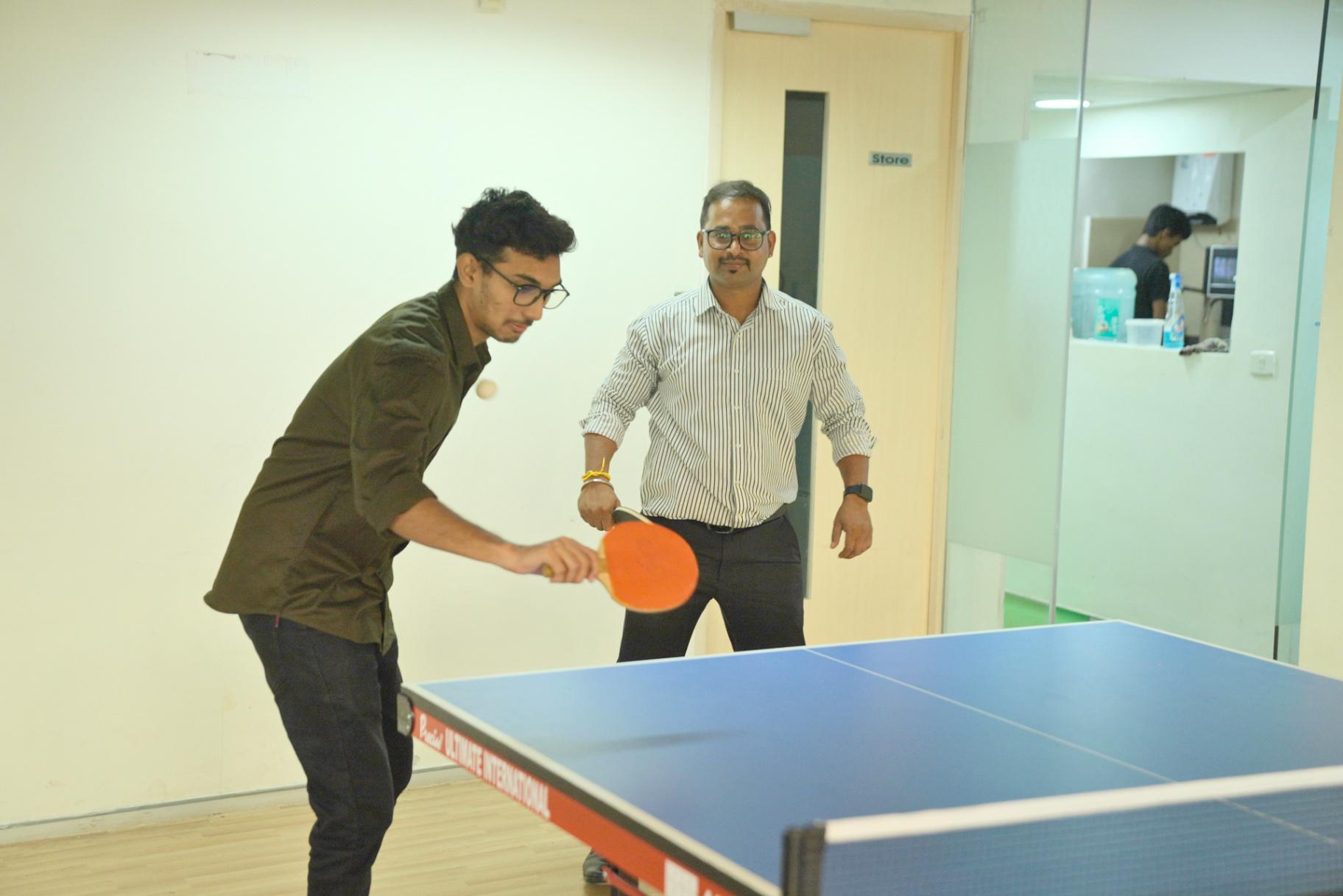 Team enjoying a game of table tennis at the office